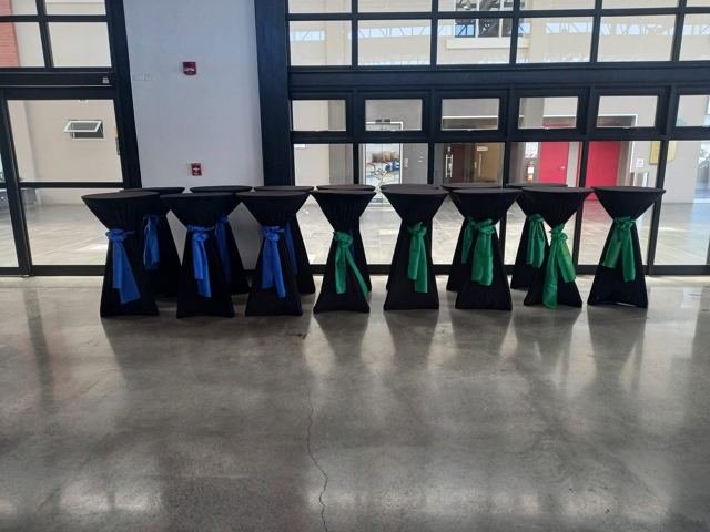 Fila de cocteleras negras con lazos azul y verde