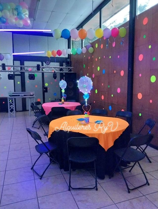 Mesa redonda con mantel neón naranja y sillas plegables negras