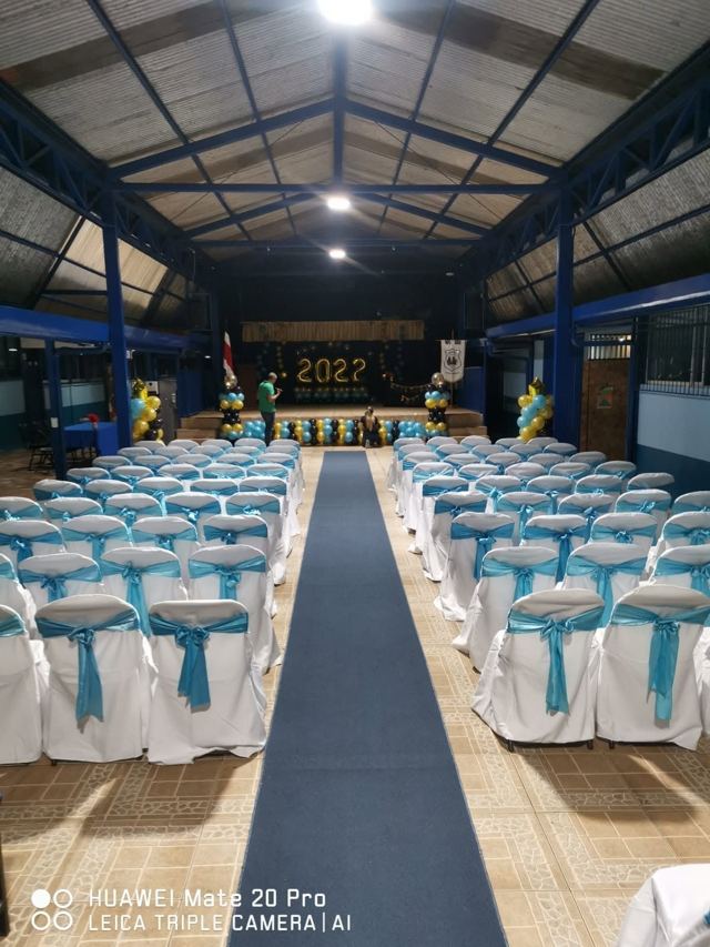 Graduación con sillas forradas blancas lazo turquesa y pasillo