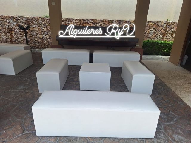 Sala lounge de cubos y bancas blancas en terraza techada