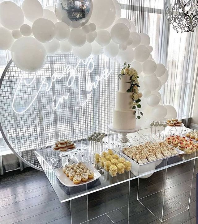 Mesa acrílica de postres con letrero neón y globos