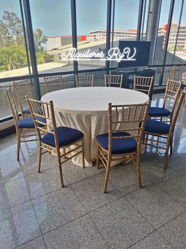 Mesa redonda mantel champagne con sillas Tiffany doradas cojín azul