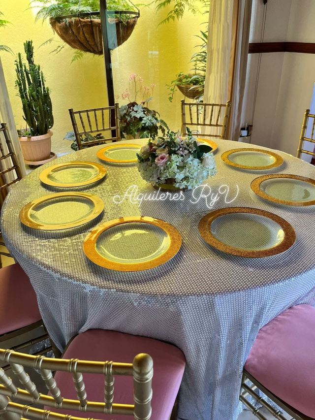 Platos base de vidrio dorado sobre mantel de lentejuelas