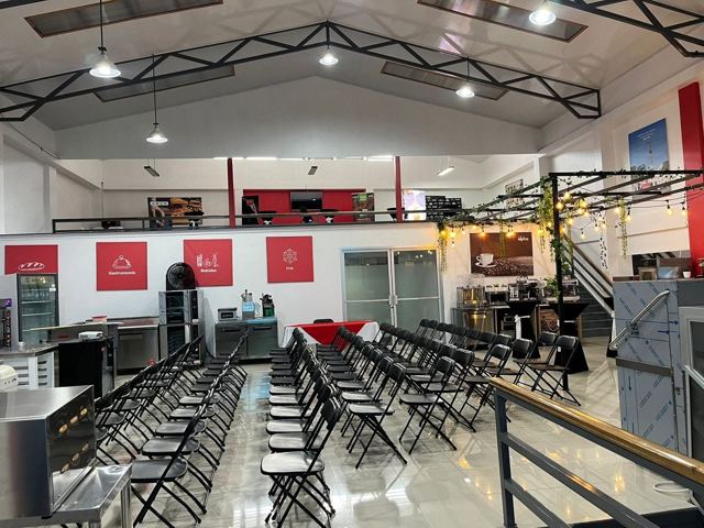 Sillas plegables negras en filas en salón de eventos
