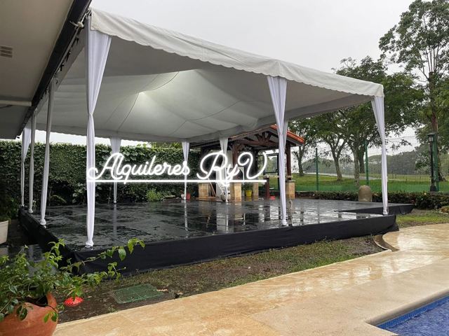 Toldo blanco sobre tarima negra junto a piscina