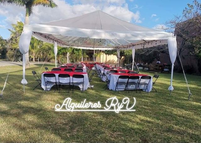 Toldo en jardín con mesas mantel rojo
