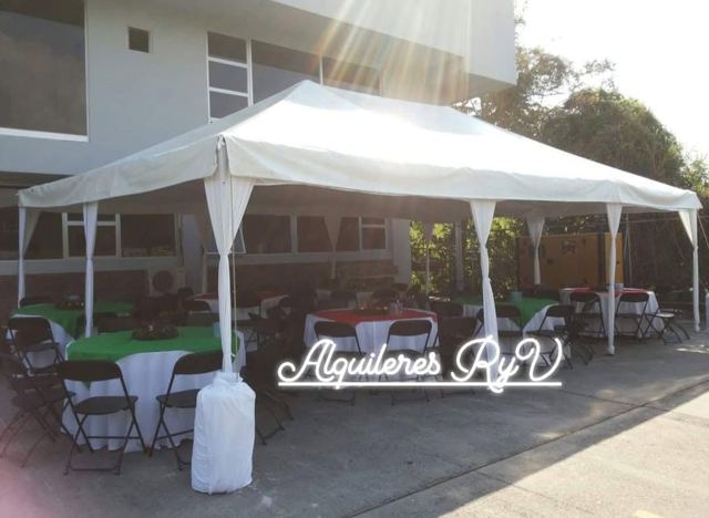 Toldo blanco con mesas de manteles verde y rojo