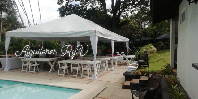 Toldo con mesas junto a piscina