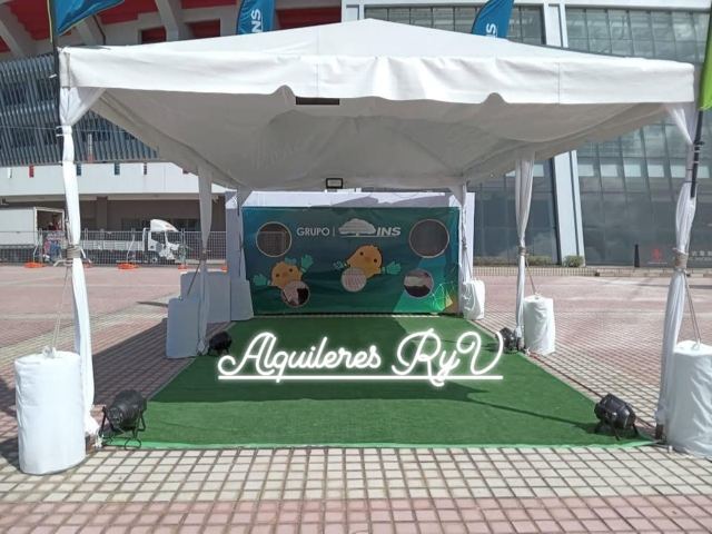 Toldo blanco con piso de césped sintético para stand