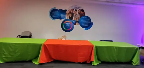 Mesas rectangulares con manteles verde y naranja para un festival