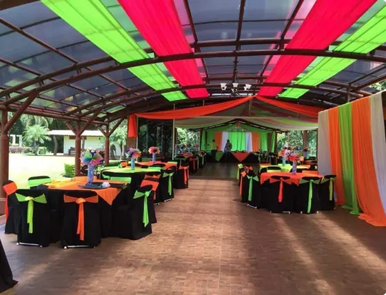 Salón decorado con telas y manteles neón verde y naranja