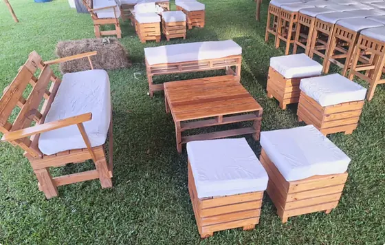 Sala lounge de tarimas de madera con cubos blancos sobre el césped