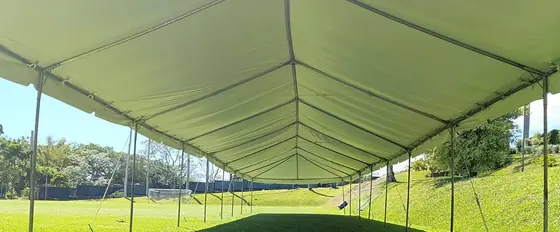 Toldo largo blanco instalado sobre césped para un evento al aire libre