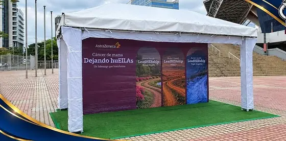 Toldo blanco con piso de césped sintético para una activación de marca en una plaza
